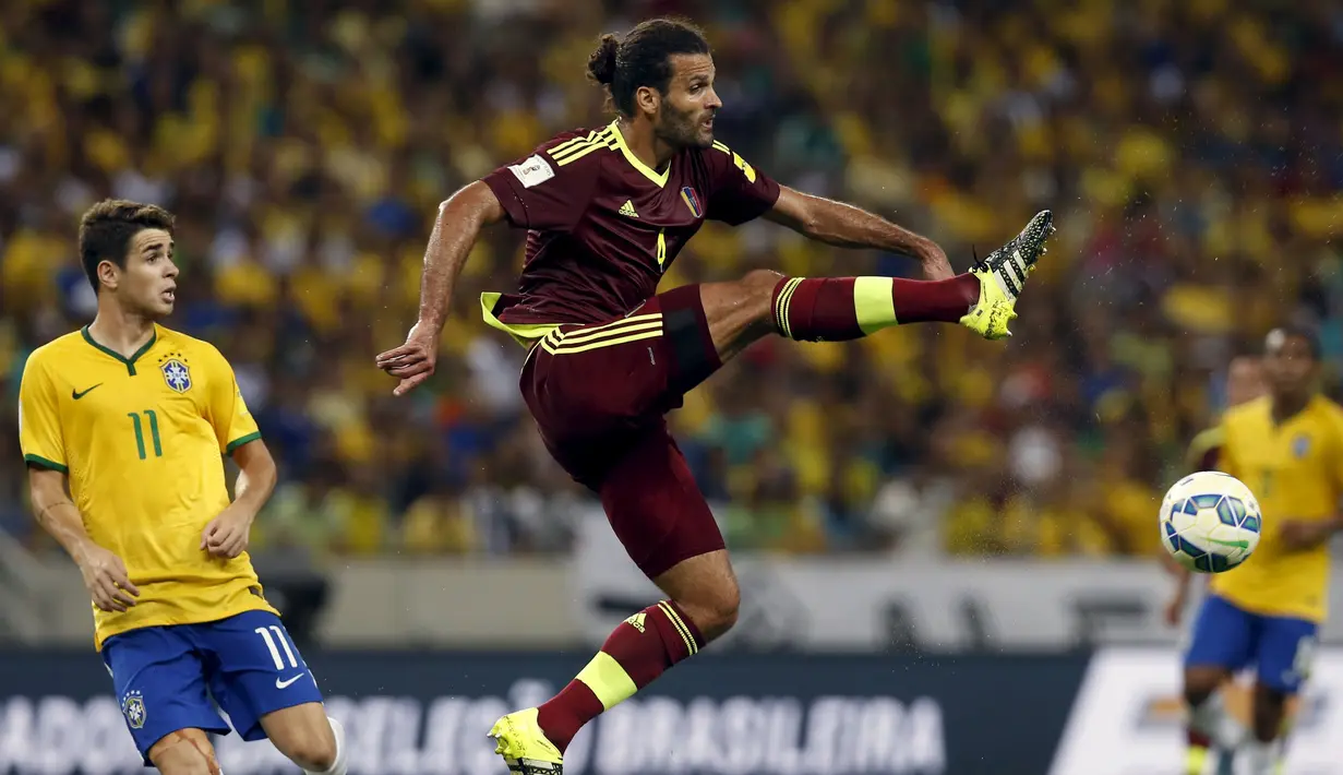 Bek Venezuela Oswaldo Vizcarrondo (kanan)  menendang bola selama pertandingan kualifikasi Piala Dunia 2018  di Stadion Fortaleza , Brasil, Rabu (14/10/2015).  Gol Brazil dicetak oleh Willian dan  Ricardo Oliveira. (REUTERS/Paulo Whitaker)