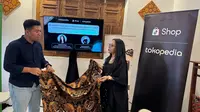 Pemilik Batik Arkanza, Mahfud Fadholi menunjukan kain batik kepada&nbsp;Communication Senior Lead Tokopedia and TikTok E-Commerce, Antonia Adega.(Liputan6.com/Fajar Abrori)