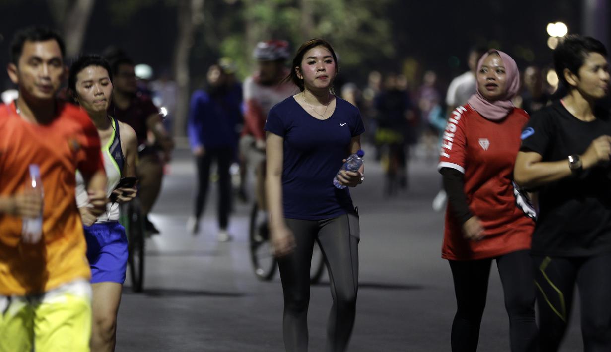 Sejumlah warga berlari di kawasan Stadion Utama Gelora Bung Karno, Senayan, Jakarta, Rabu (9/10). Olahraga lari pada malam hari di GBK menjadi pilihan pekerja ibu kota. (Bola.com/Yoppy Renato)