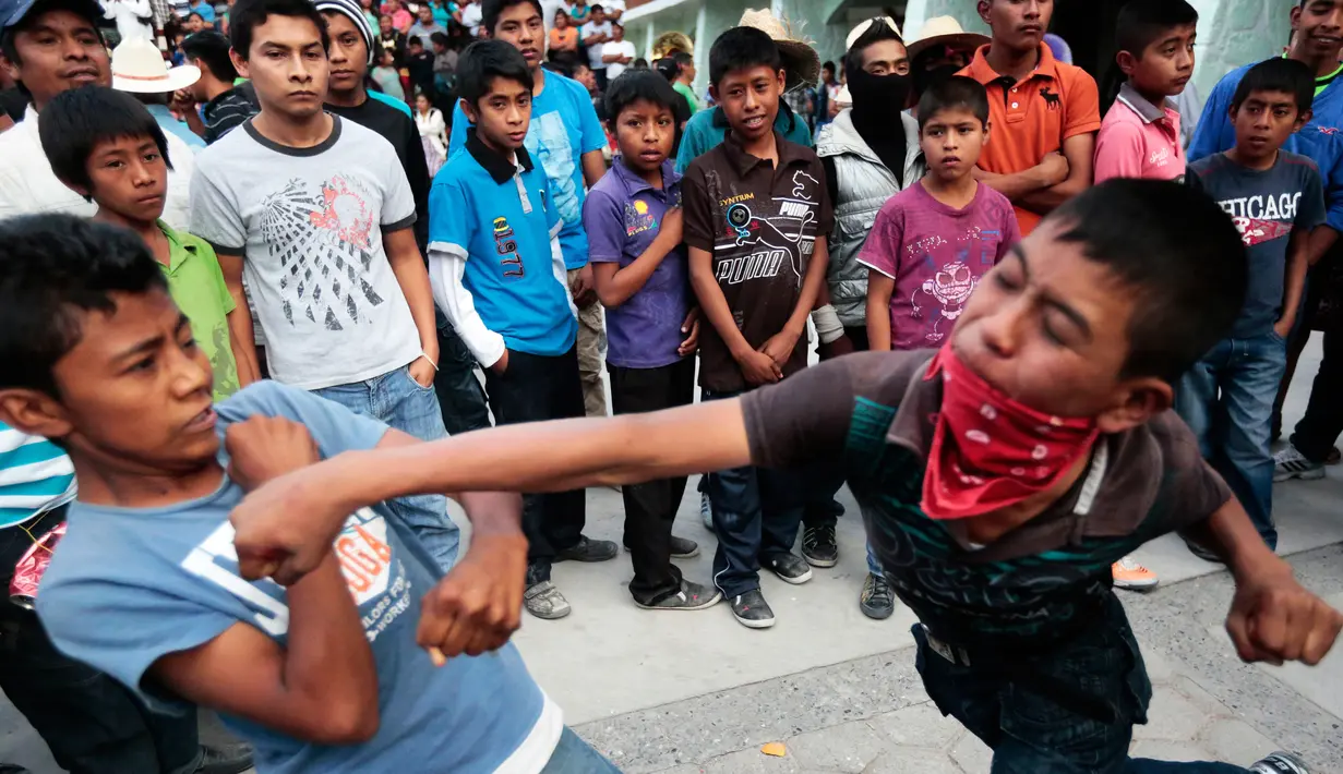 Dua anak saling pukul saat mengikuti Tradisi Xochimilcas di Zitlala, Guerrero, Meksiko (18/2). Tradisi ini berasal dari warga pribumi atau keturunan dari Suku Aztec. (AFP PHOTO/Pedro Pardo)