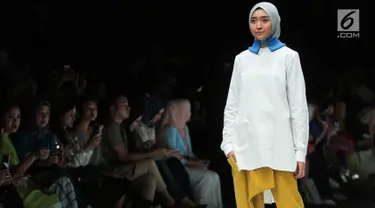 Model berpose membawakan busana rancangan kolaborasi antara desainer L.tru dan Mice Cartoon di Jakarta Fashion Week 2018 di Senayan City, Jakarta, Selasa (24/10). L.tru dan Mice Cartoon mengangkat tema "Dear Women. (Liputan6.com/Faizal Fanani)