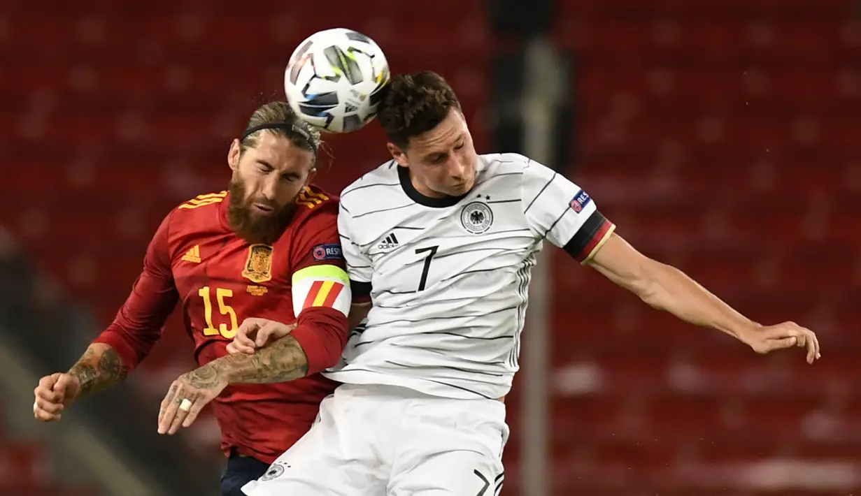 Gelandang Jerman, Julian Draxler, berebut bola dengan bek Spanyol, Sergio Ramos, pada laga Nation League di Mercedes-Benz Arena, Berlin, Jumat (4/9/2020) dini hari WIB. Jerman bermain imbang 1-1 atas Spanyol. (AFP/Thomas Kienzle)