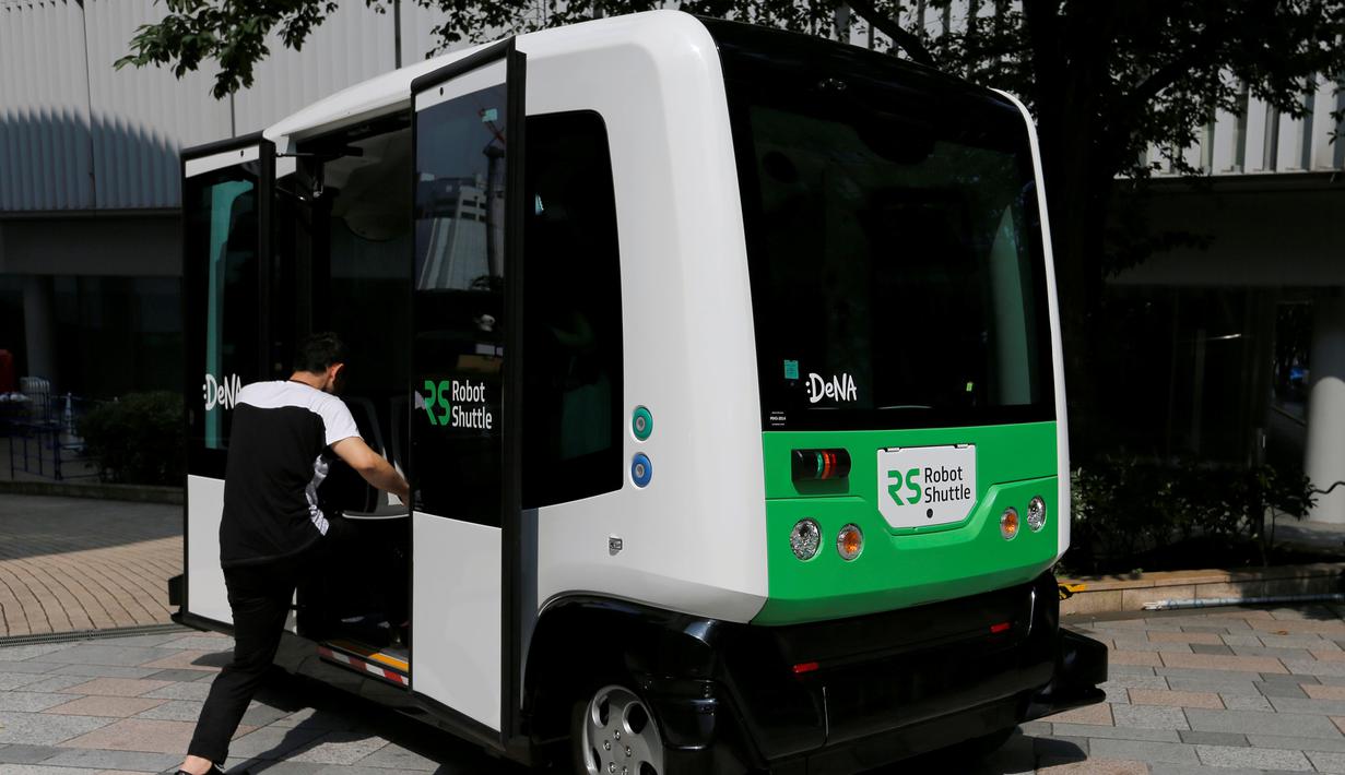 Seorang lelaki memasuki Robot Shuttle saat didemonstrasikan di Tokyo, Jepang, Kamis (7/7). Robot Shuttle adalah bus kemudi otomatis sehingga tak membutuhkan sopir untuk pengoperasiannya. (REUTERS / Toru Hanai)