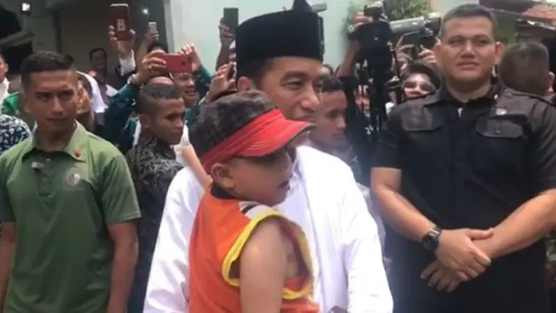 Presiden Jokowi memeluk dan menggendong seorang anak berkebutuhan khusus saat menyambangi Cianjur, Jawa Barat.