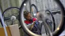 Seorang pekerja memasangkan pedal sepeda listrik Velib di pabrik Arcade Cycle di Paris, Prancis, (19/12). Sepeda yang dibuat dipabrik ini untuk disewakan di kota-kota di seluruh dunia khususnya di Prancis. (AFP Photo/Loic Venance)
