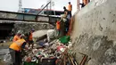 Petugas UPK Badan Air Dinas Kebersihan DKI Jakarta mengangkut tumpukan sampah dari badan Kali Ciliwung Kwitang, Jakarta, Senin (10/10). Setiap harinya sekitar 90-220 ton sampah diangkat dari badan air. (Liputan6.com/Helmi Fithriansyah)
