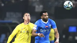 Pemain Al-Nassr, Cristiano Ronaldo, duel udara dengan pemain Al-Hilal, Al Bulayhi, pada laga persahabatan di Kingdom Arena, Riyadh, Jumat (9/2/2024). (AP Photo)