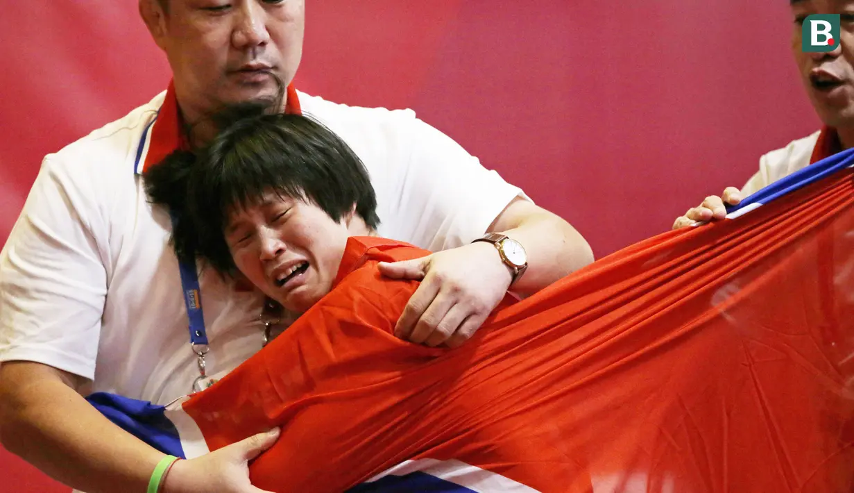 Pegulat Korea Utara, Pak long Ming, menangis usai berhasil mengalahkan pegulat Kazakstan, Zhuldyz Eshimova, pada laga Asian Games di Jakarta, Senin (208/2018).  (AP/Firdia Lisnawati)