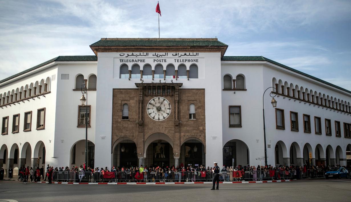 Warga melakukan penyambutan saat parade Timnas Maroko di Rabat, Maroko, 20 Desember 2022. Timnas Maroko mendapat sambutan hangat di negaranya setelah berhasil meraih juara keempat Piala Dunia 2022. (AP Photo/Mosa'ab Elshamy)