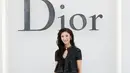 Ejae tampil berkilau dengan atasan peplum dan rok midi bertabur glitter hitam-putih. Dilengkapi anting bunga warna-warni dan heels pink berhias bunga. [dok. Dior]