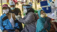 Warga menerima vaksin virus corona COVID-19 Sinovac di klinik vaksinasi massal darurat di lapangan sepak bola di Surabaya, Jawa Timur, Selasa (6/7/2021). Indonesia tengah memerangi gelombang infeksi baru yang belum pernah terjadi sebelumnya. (JUNI KRISWANTO/AFP)