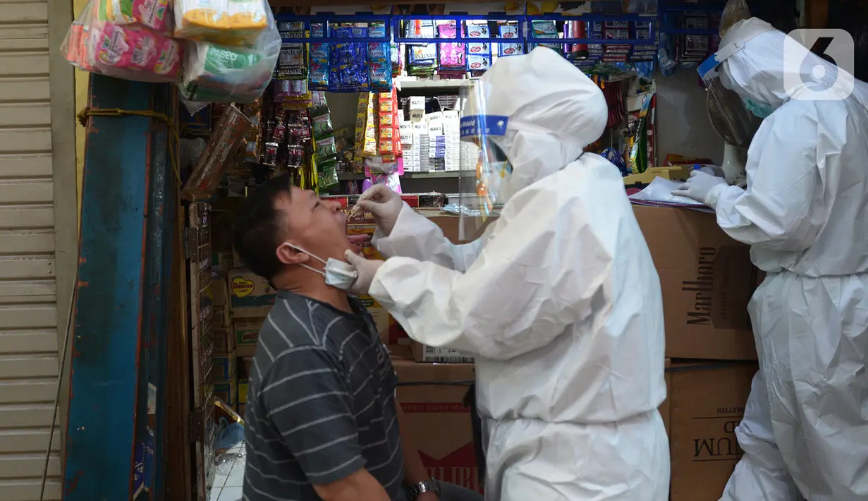 Petugas medis melakukan tes usap (swab test) ke pedagang Pasar Karang Anyar di Jakarta, Kamis (26/6/2020). Tes swab dengan metode PCR dilakukan secara masif setelah adanya pelonggaran PSBB, terutama di wilayah yang berpotensi tinggi menjadi tempat penularan Covid-19. (merdeka.com/Imam Buhori)