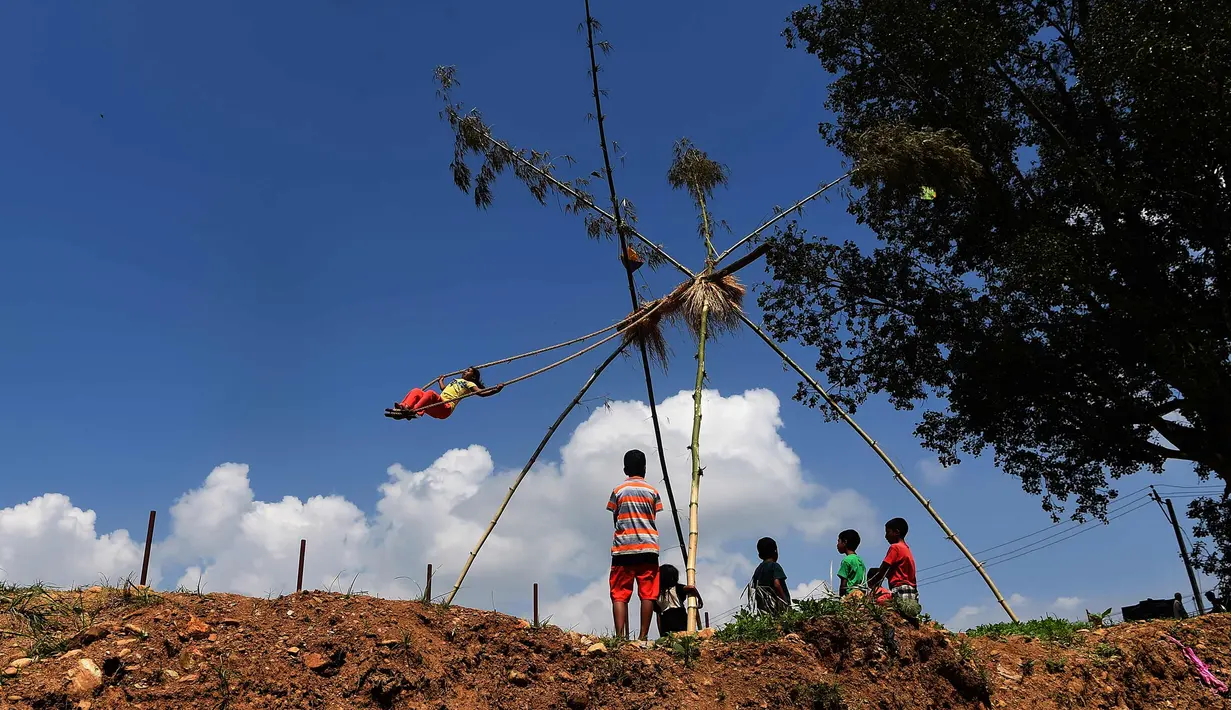 Anak-anak bermain di ayunan khas negara Nepal di Lalitpur pinggiran kota Kathmandu, Nepal (26/9). Ayunan yang dikenal dengan sebutan 'Dashain Ping' ini bisa dimainkan orang-orang dari segala usia. (AFP Photo/Prakash Mathema)