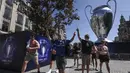 Suporter Chelsea berjalan melewati replika raksasa trofi Liga Champions di pusat kota Porto, Portugal (28/5/2021). Klub Inggris Manchester City dan Chelsea akan memainkan final Liga Champions di stadion Dragao di Porto pada Sabtu malam atau Minggu (30/5/2021) dini hari. (AP Photo/Luis Vieira)