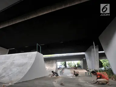 Aktivitas pekerja menyelesaikan pembangunan arena papan seluncur atau skate park dan lintasan sepeda BMX di kolong Flyover Slipi, Jakarta, Kamis (13/12). Pemprov DKI Jakarta melalui Suku Dinas Kehutanan membangun skate park. (Merdeka.com/Iqbal S. Nugroho)