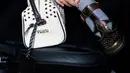 Aksesori utama yang menjadi sorotan adalah tas tangan putih dengan detail perforasi dan aksen metal yang merupakan koleksi Autumn Winter 2026 Onitsuka Tiger. Desainnya terasa futuristik namun tetap wearable, memperkuat karakter smart urban yang ingin ditampilkan. Tambahan luggage tag hitam memberi sentuhan travel aesthetic yang relevan dengan suasana Milan Fashion Week.  [@raisa6690].
