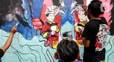 Peserta menyelesaikan pembuatan mural saat mengikuti pelatihan seni mural di Pusat Pelatihan Seni Budaya (PPSB) Jalan H Naman, Pondok Kelapa, Jakarta Timur, Selasa (24/6/2025). (Liputan6.com/Herman Zakharia)