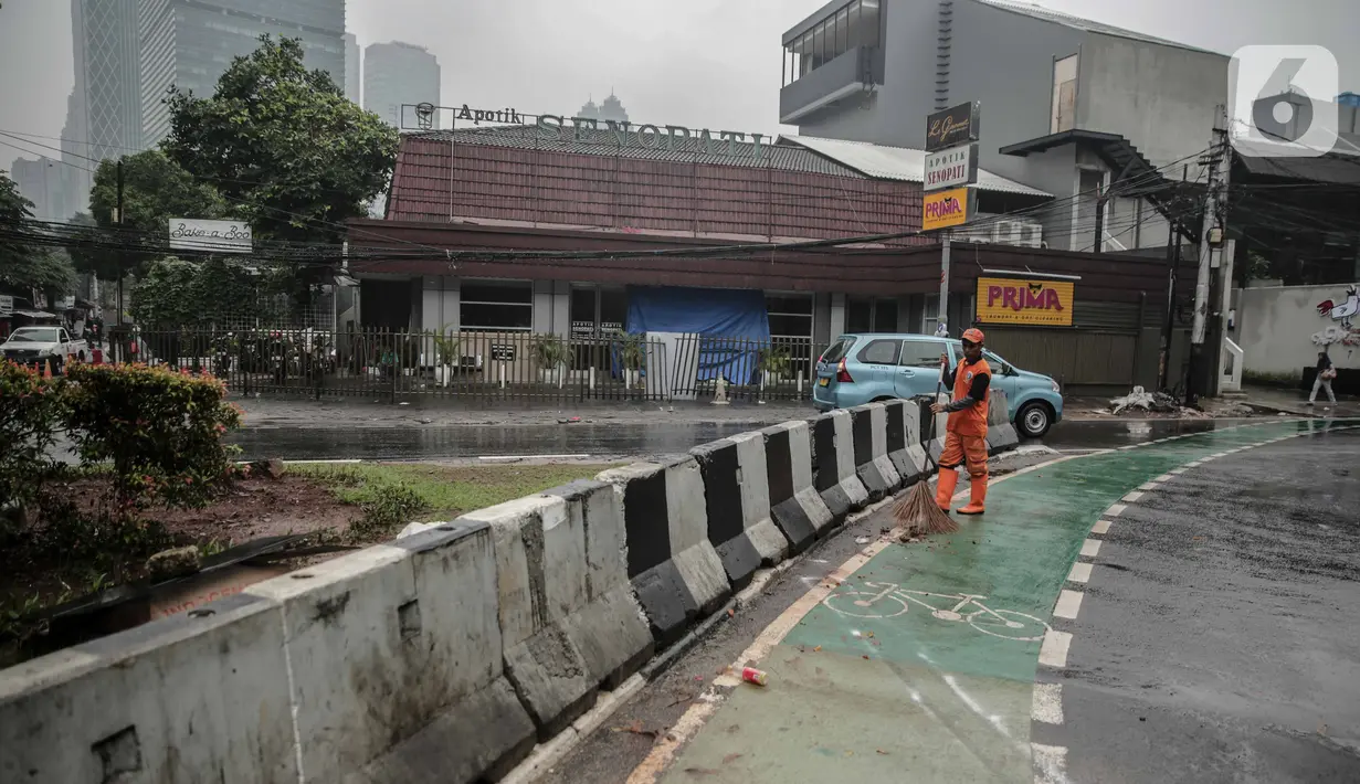 Petugas PPSU membersihkan sampah dekat beton pembatas di Jalan Senopati, Jakarta, Minggu (29/12/2019). Pascakejadian mobil tabrak Apotek Senopati, Suku Dinas Bina Marga memasangan beton pembatas untuk meminimalisir kejadian serupa terulang kembali. (Liputan6.com/Faizal Fanani)