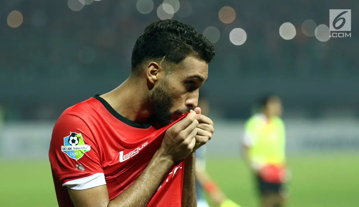 Bek Persija, Willian Pachecho mencium logo tim usai memenangi laga melawan Arema FC dilanjutan Liga 1 Indonesia di Stadion Patriot Candrabhaga, Bekasi, Jumat (2/6). Persija unggul 2-0 atas Arema FC. (Liputan6.com/Helmi Fithriansyah)