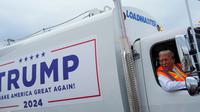 Donald Trump mengendarai truk sampah berwarna putih dengan tulisan "TRUMP, Make America Great Again 2024" (Dok. AP).