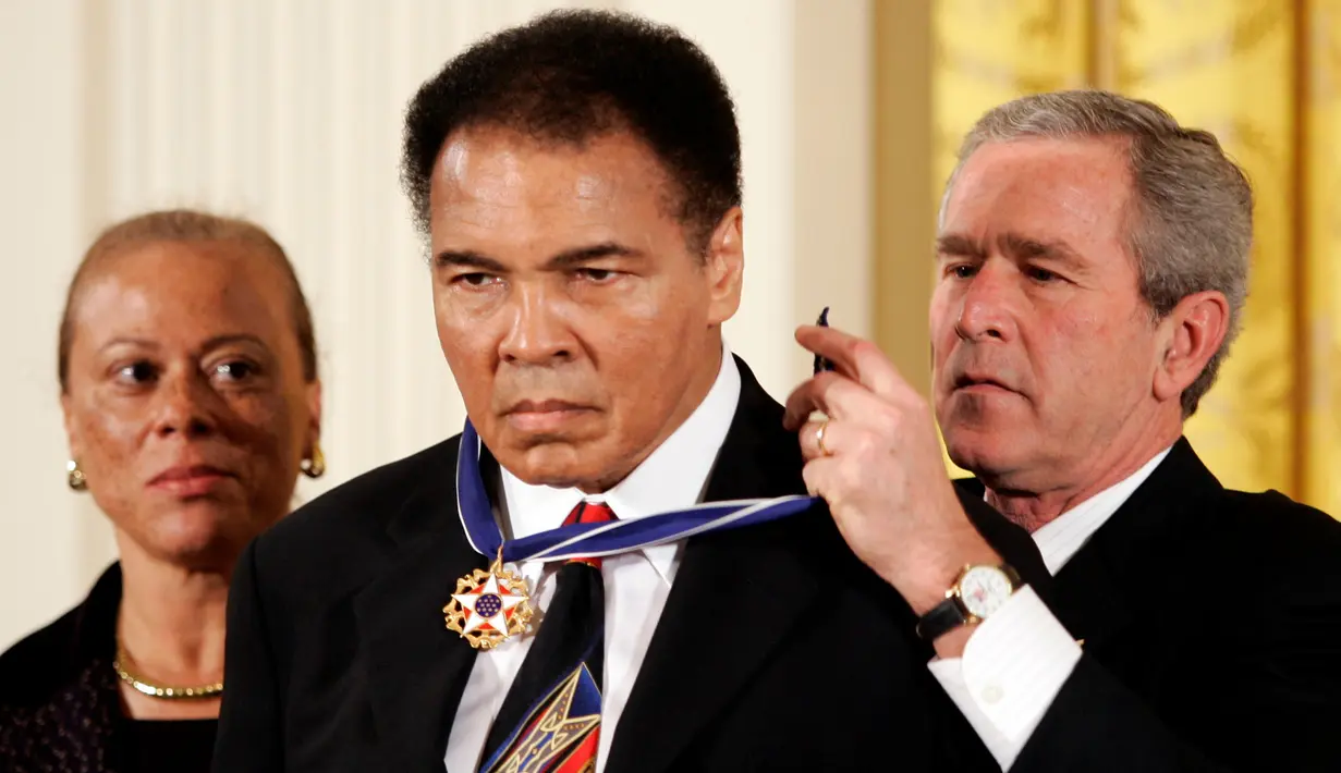 Mantan Presiden AS George W. Bush (kanan) saat memberikan penghargaan kepada Muhammad Ali di gedung putih,Washington, 9 November 2005. Muhammad Ali meninggal karena penyakit komplikasi pernapasan sejak Kamis lalu. (REUTERS / Kevin Lamarque)
