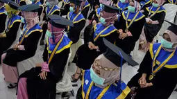 Sejumlah pelajar yang memakai masker sebagai tindakan pencegahan terhadap virus corona COVID-19 mengikuti acara wisuda SMK Farmasi di Banda Aceh (24/9/2020). (AFP/Chaideer Mahyuddin)