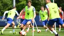 Bek Chelsea, Marcos Alonso (tengah) menggiring bola saat mengikuti latihan tim di Chelsea Training Ground, di Cobham, Surrey (22/5/2019). Chelsea akan bertanding melawan Arsenal pada babak Final Liga Europa pada 29  Mei di Baki Olimpiya Stadionu. (AFP Photo/Ben Stansall)