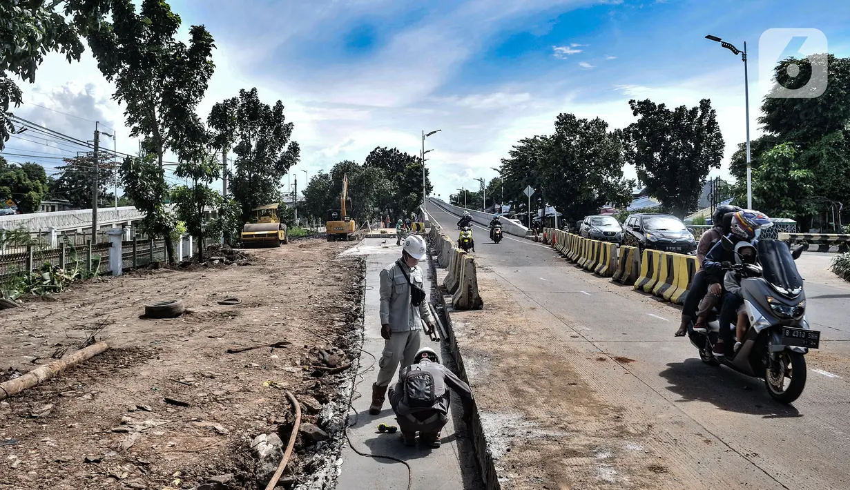 Pengendara motor melintasi pekerja yang beraktivitas saat menerobos flyover tapal kuda Lenteng Agung, Jakarta, Minggu (28/2/2021). Peristiwa ini dapat membahayakan pengendara sepeda motor karena aktivitas pembangunan flyover masih berlangsung. (merdeka.com/Iqbal S Nugroho)