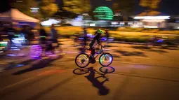 Seorang peserta mengendarai sepedanya dengan hiasan lampu saat berpartisipasi dalam acara Bike the Night di Vancouver, BC, (16/9). Penyelenggara mengharapkan lebih dari 5.000 orang untuk berpartisipasi dalam acara ini. (Darryl Dyck/Canadian Press via AP)
