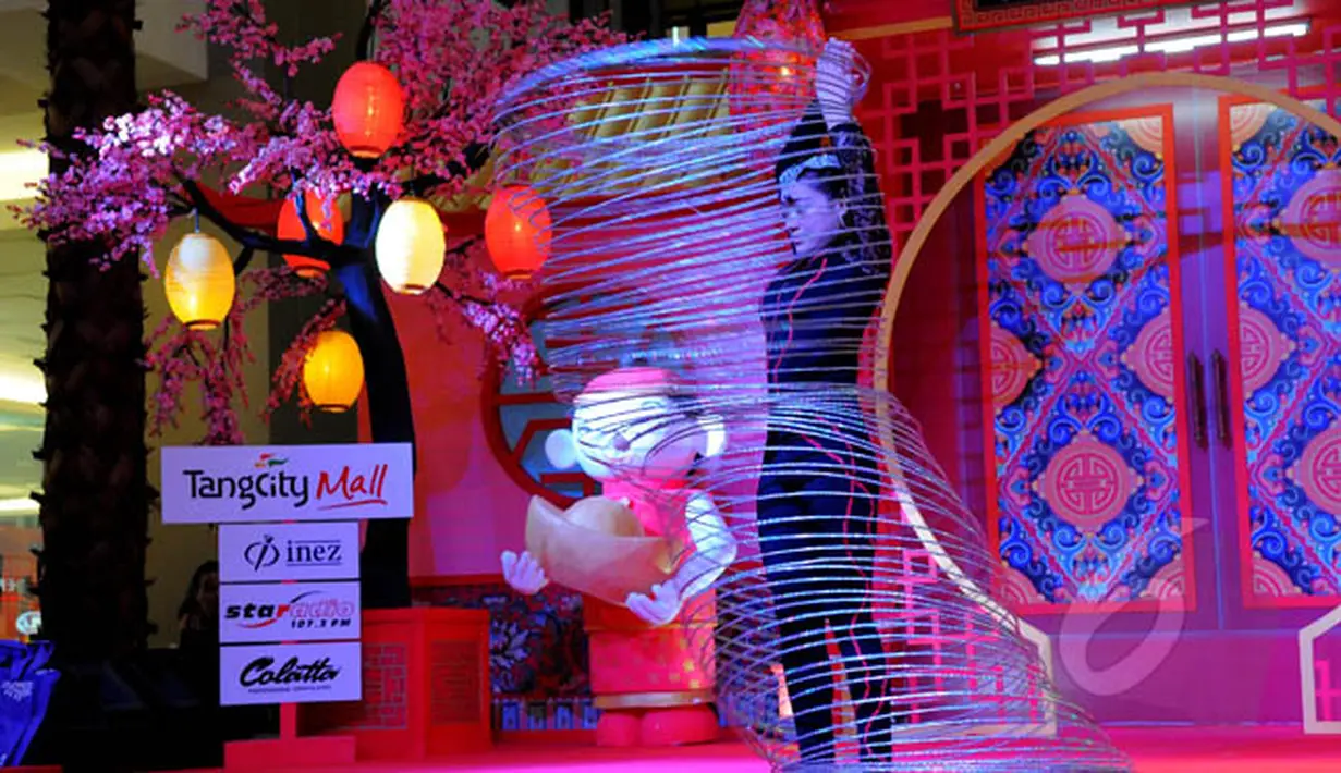 Aksi pemain akrobat bermain hollahop dalam pertunjukan "The Dazzling Duo Chinese Acrobatic Show" di Tangerang City Mall, Tangerang, Jumat (20/2/2015). Pertunjukan akrobat dalam rangka memperingati Imlek 2566. (Liputan6.com/Faisal R Syam) 
