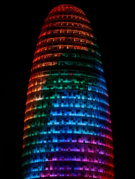 Proyeksi cahaya warna pelangi menerangi gedung pencakar langit Torre Agbar saat peringatan World Pride di Barcelona, Spanyol, 28 Juni 2017. World Pride merupakan acara perayaan LGBT terbesar di dunia yang diadakan setiap tahun. (AP/Manu Fernandez)
