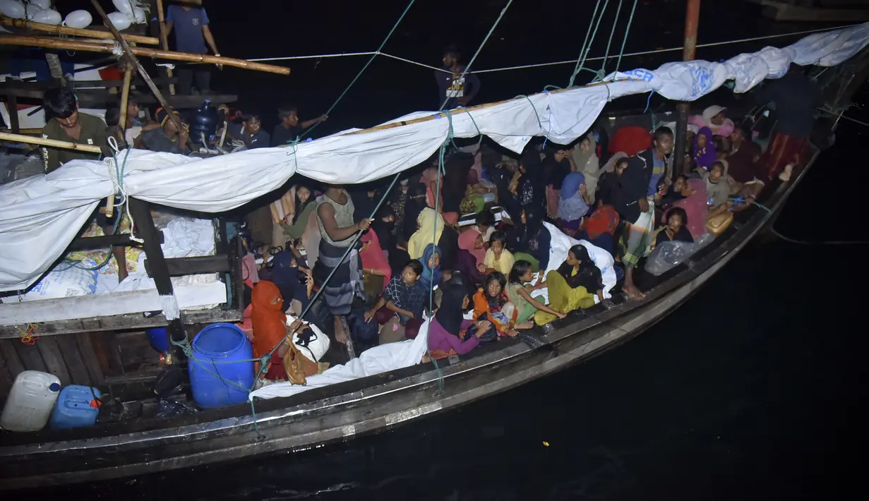 Pengungsi Rohingya duduk di perahu saat tiba di Pelabuhan Krueng Geukueh di Aceh Utara, Jumat pagi (31/12/2021). Sedikitnya 120 orang etnis Rohingya yang sempat terombang-ambing di lautan selama beberapa hari akhirnya dievakuasi ke daratan Aceh. (AP Photo/Rahmat Mirza)