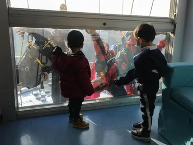 Dua orang berpakaian superhero turun dari atap untuk memberi kejutan di jendela kamar pasien anak di bangsal Pediatri rumah sakit San Paolo di Milan, Italia, Rabu (15/12/2021). Aksi Spiderman dan kawan-kawannya itu untuk menghibur anak-anak yang dirawat di rumah sakit tersebut. (AP Photo/Luca Bruno)