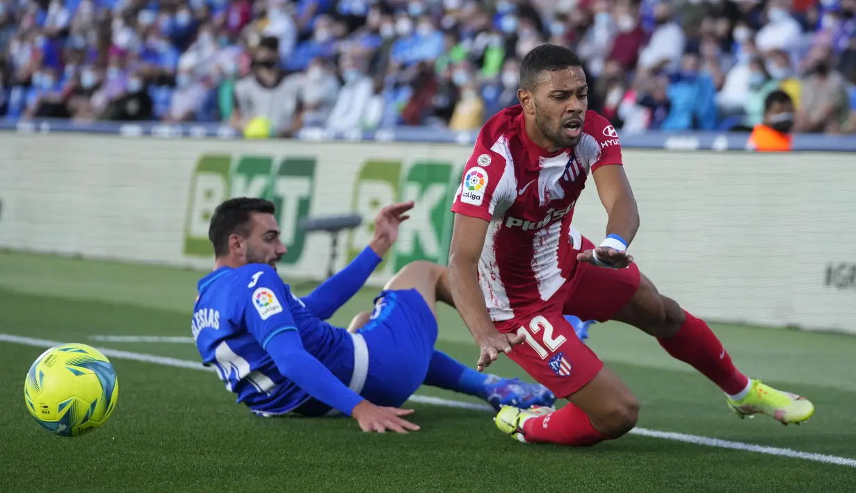 Gelandang Atletico Madrid, Renan Lodi (kanan) berebut bola dengan bek Getafe, Juan Iglesias pada laga pekan keenam Liga Spanyol di Stadion Coliseum Alfonso Perez, Rabu (22/9/2021) dini hari WIB. Luis Suarez memborong dua gol saat Atletico Madrid mengalahkan Getafe 2-1. (AP Photo/Manu Fernandez)