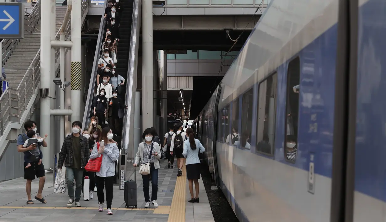 Penumpang memakai masker untuk membantu melindungi dari penyebaran virus corona bersiap untuk naik kereta menjelang liburan Chuseok atau Hari Thanksgiving versi Korea di Stasiun Kereta Seoul di Seoul, Korea Selatan, Selasa (29/9/2020). (AP Photo / Ahn Young-joon)
