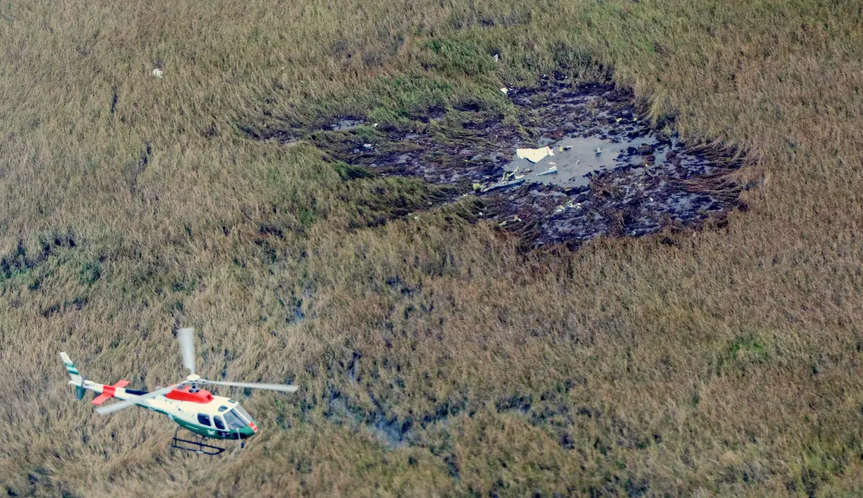 Helikopter terbang di atas puing-puing pesawat Beechcraft Baron yang jatuh dekat bandara di Ayolas, Paraguay, Kamis (26/7). Kecelakaan tersebut menewaskan empat orang. (Carlos Juri/Grupo La Nacion/AFP)