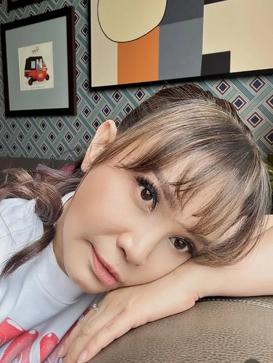 <p>Kali ini poninya tampak ditata poni depan yang tidak terlalu tebal. Tentu membuat tampilan ibu satu anak ini terlihat cute. [@itsrossa910]</p>