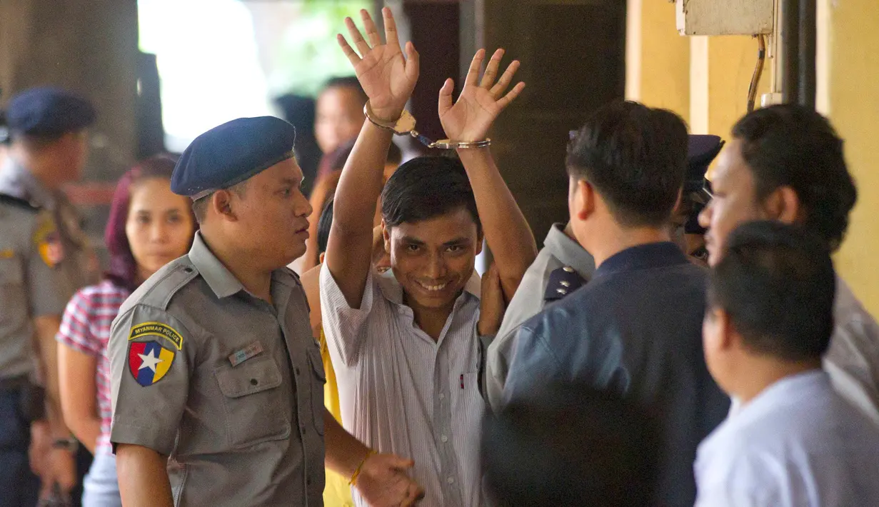 Wartawan Reuters, Kyaw Soe Oo (tengah) dikawal oleh polisi setibanya di pengadilan distrik Yangon, Myanmar, Senin (3/9). Dua jurnalis Reuters dituduh melanggar undang-undang rahasia negara saat menyelidiki kekerasan terhadap Rohingya. (AP/Thein Zaw)