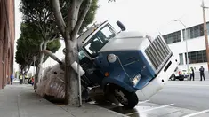 Sebuah truk terjebak di sebuah saluran pembuangan di San Francisco, AS, Jumat (5/5). Diduga karena muatan yang terlalu berat membuat bagian atas saluran pembuangan menjadi amblas. (AP Photo / Jeff Chiu)