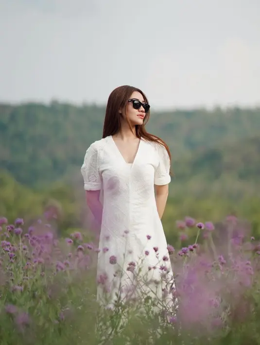 Aaliyah Massaid memang memiliki gaya khas yang simpel. Di sini, ia berfoto di tengah kebuh bunga mengenakan sebuah dress lengan pendek berwarna putih. [Foto: Instagram/aaliyah.massaid]