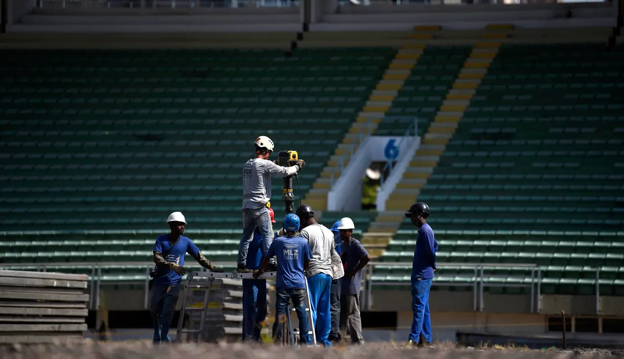 Pekerja memulai pembangunan rumah sakit darurat bagi pasien terinfeksi Covid-19 di kompleks stadion Maracana, Rio de Janeiro, Kamis (2/4/2020). Sebagian kompleks stadion paling terkenal di Brasil itu diubah menjadi rumah sakit lapangan selama pandemi Covid-19. (MAURO PIMENTEL/AFP)