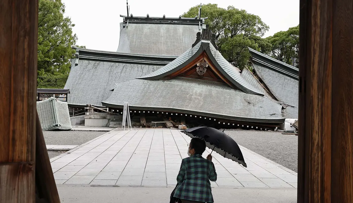 Seorang pengunjung melihat atap-atap yang runtuh dari Kuil Yatsuhiro, sehari setelah gempa bumi di Yatsushiro, prefektur Kumamoto, Rabu, 29 Juli 2026. (Juntaro Yokoyama/Kyodo News via AP)
