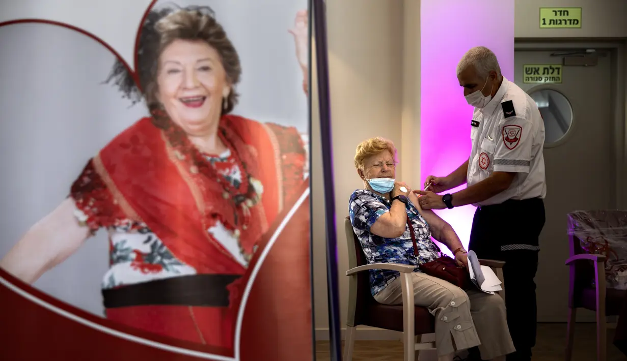 Ahuva Litman (86) menerima dosis ketiga vaksin COVID-19 Pfizer-BioNTech di panti jompo swasta, di Netanya, Israel, Minggu (1/8/2021). Israel pada 29 Juli 2021 memulai kampanye dosis vaksin Covid-19 ketiga untuk warga berusia 60 tahun ke atas. (AP Photo/Oded Balilty)