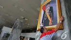 Petugas memasang foto Presiden Jokowi di pilar Gedung Nusantara III Kompleks Parlemen Senayan, Selasa (23/12/2014). (Liputan6.com/Andrian M Tunay)