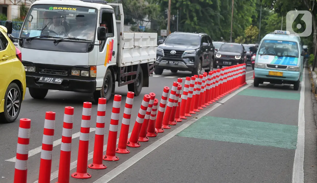 Kendaraan bermotor melintas di samping stick cone pembatas jalur sepeda di Kawasan Jalan Penjernihan Jakarta, Sabtu (10/12/2022). Keadaan stick cone untuk pembatas jalur sepeda tersebut terlihat sudah rusak dan tidak terpasang dengan benar. (Liputan6.com/Angga Yuniar)