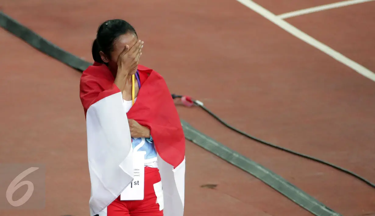 Atlet putri Indonesia, Triyaningsih menutup wajahnya usai finis pertama di nomor 10.000 M di National Stadium Singapura, Kamis (11/6/2015). Triyaningsih mencatatkan waktu 33 menit 44,53 detik dan berhasil meraih emas. (Liputan6.com/Helmi Fithriansyah)