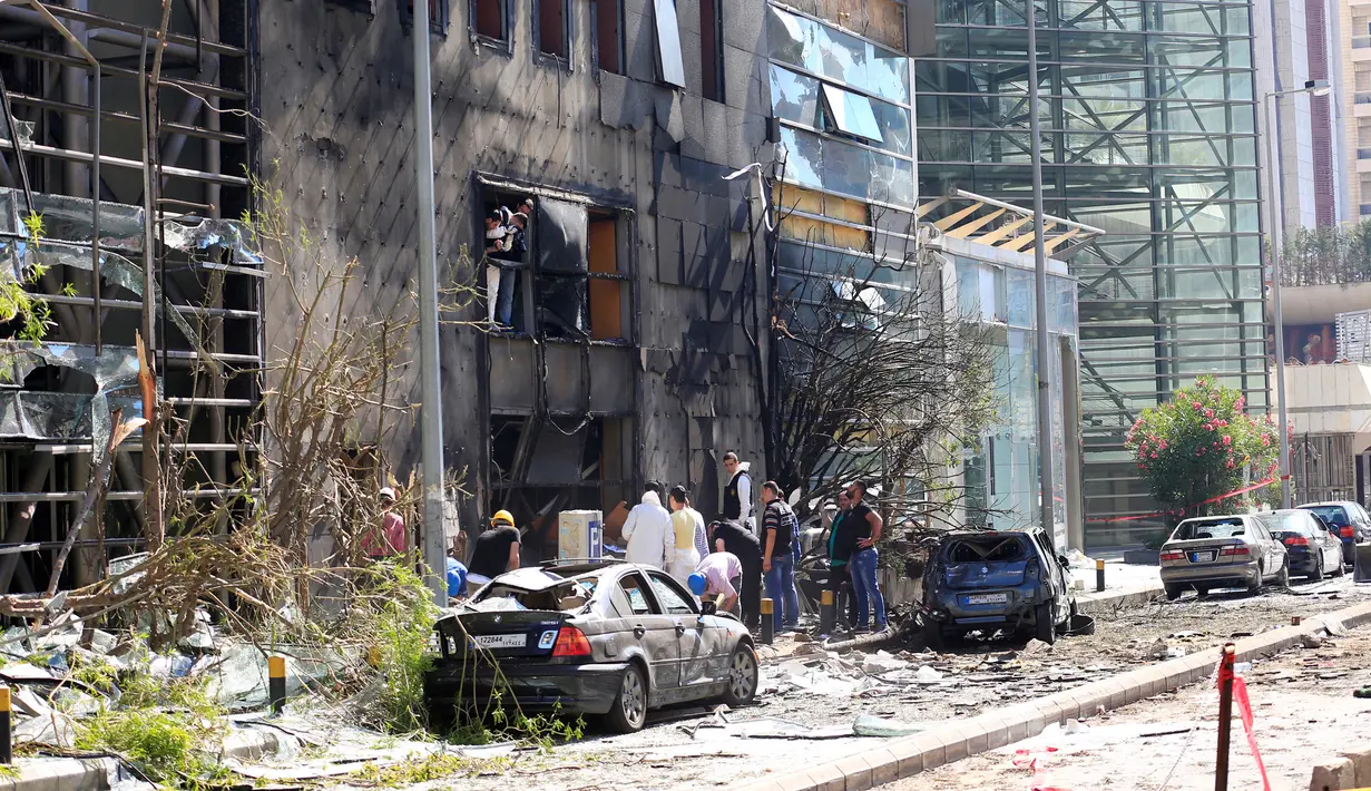 Warga dan petugas saat memeriksa kerusakan yang terjadi di Bank Blom pasca ledakan di Beirut, Lebanon (13/6). Bom meledak di sekitar Bank Blom pada Minggu (12/6) malam. (REUTERS/Jamal Saidi)
