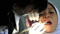 Dokter memeriksa gigi seorang siswa di Fakultas Kedokteran Gigi Moestopo, Jakarta, Senin (23/11/2015). Bulan Kesehatan Gigi Nasional bertujuan untuk mengedukasi mengenai pentingnya merawat kesehatan gigi. (Liputan6.com/Johan Tallo) 