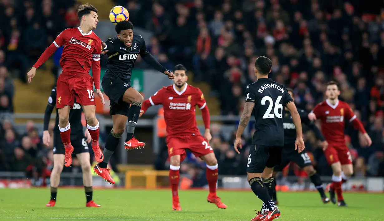 Pemain Liverpool, Philippe Coutinho berebut bola dengan pemain Swansea City,  Leroy Fer pada laga pekan ke-20 Premier League di Stadion Anfield, Rabu (27/12). Di hadapan suporternya sendiri, Liverpool mencukur Swansea City 5-0. (Peter Byrne/PA via AP)