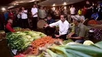 Presiden Joko Widodo berbincang dengan pedagang sayuran ketika memantau kebutuhan bahan pokok di Pasar Bogor, Jalan Roda, Kota Bogor, Selasa (30/10). Jokowi ingin memastikan langsung harga bahan kebutuhan pokok di pasar (Liputan6.com/HO/Biro Pers Setpres)